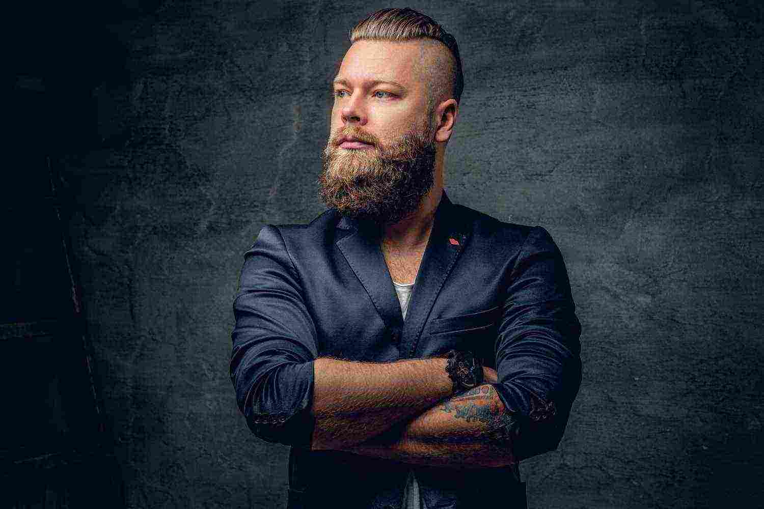 berded hipster male with crossed arms dressed violet suit grey vignette background