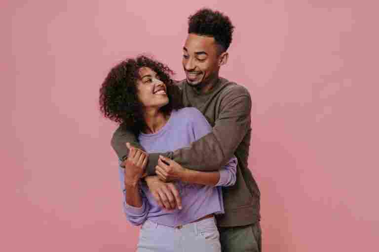 couple love looking each other with love smiling pink wall