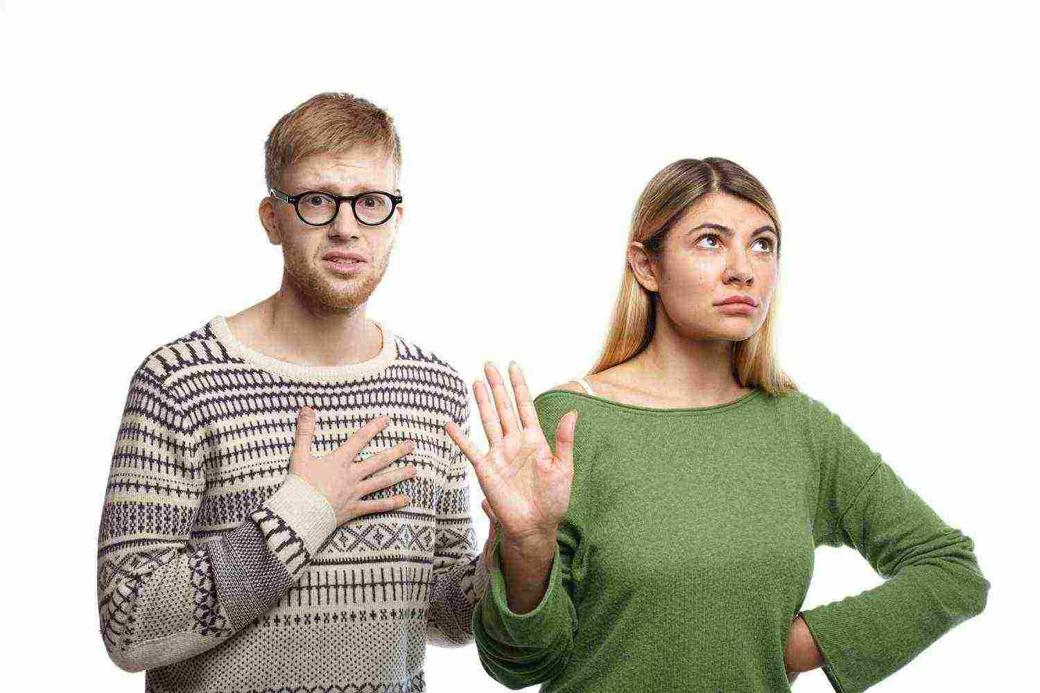 displeased blonde girl showing stop sign with her palm meaning it s while her unhappy miserable boyfriend with unhappy look holding hand his chest as sign broken heard