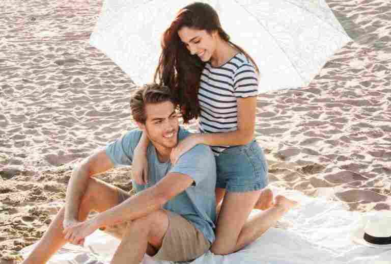 girl giving massage boyfriend beach