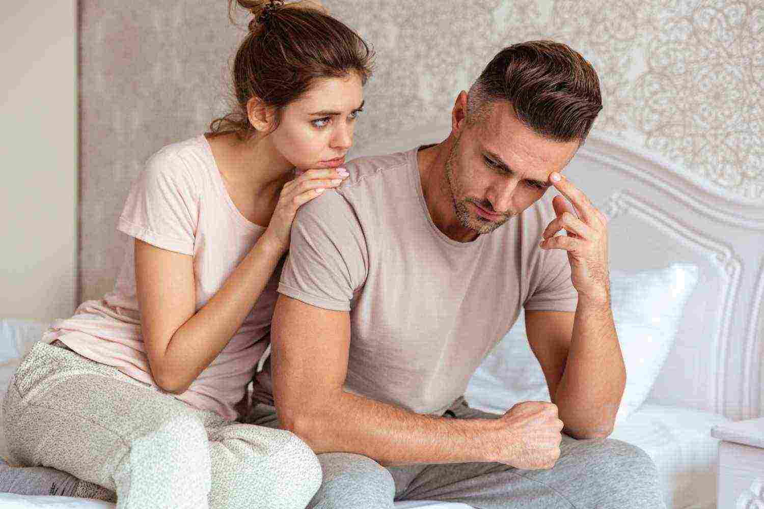 lovely couple sitting bed while woman calm down her boyfriend which upset1