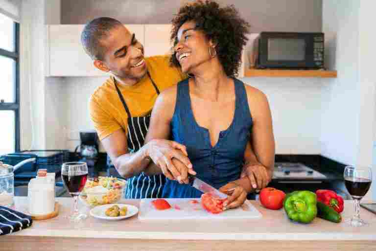 portrait young latin couple cooking together kitchen home relationship cook lifestyle concept