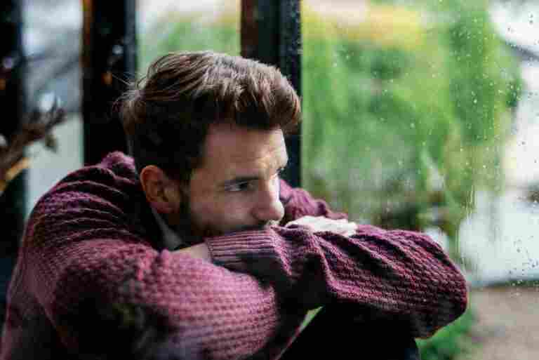 thoughtful man looking out window