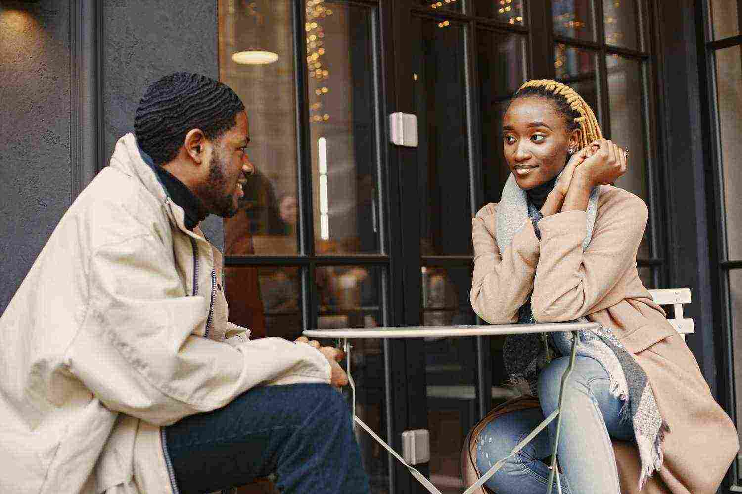 two young people sitting outside african couple enjoying time spending with each other