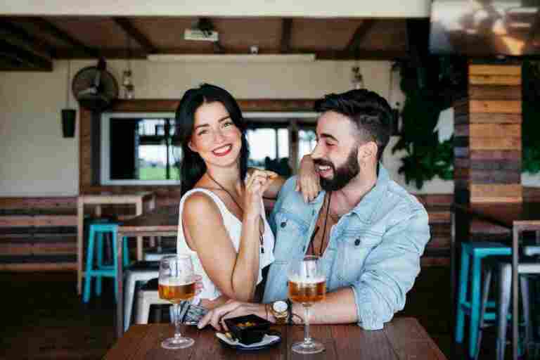 couple bar laughing with beer