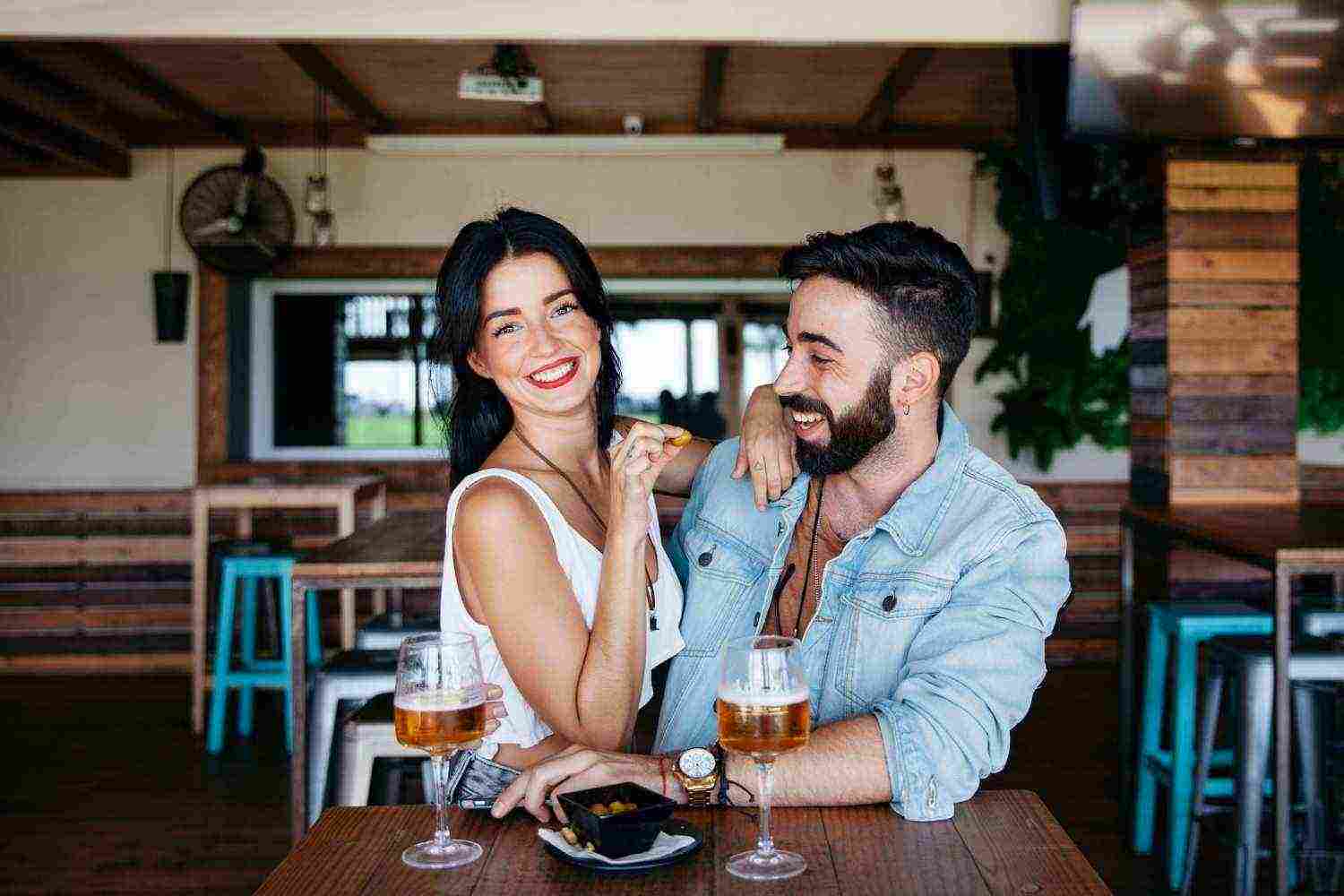 couple bar laughing with beer