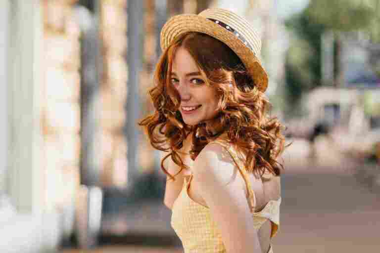 enchanting girl with dark curly hair fooling around outdoor warm summer day amazing ginger female model hat yellow dress laughing urban street
