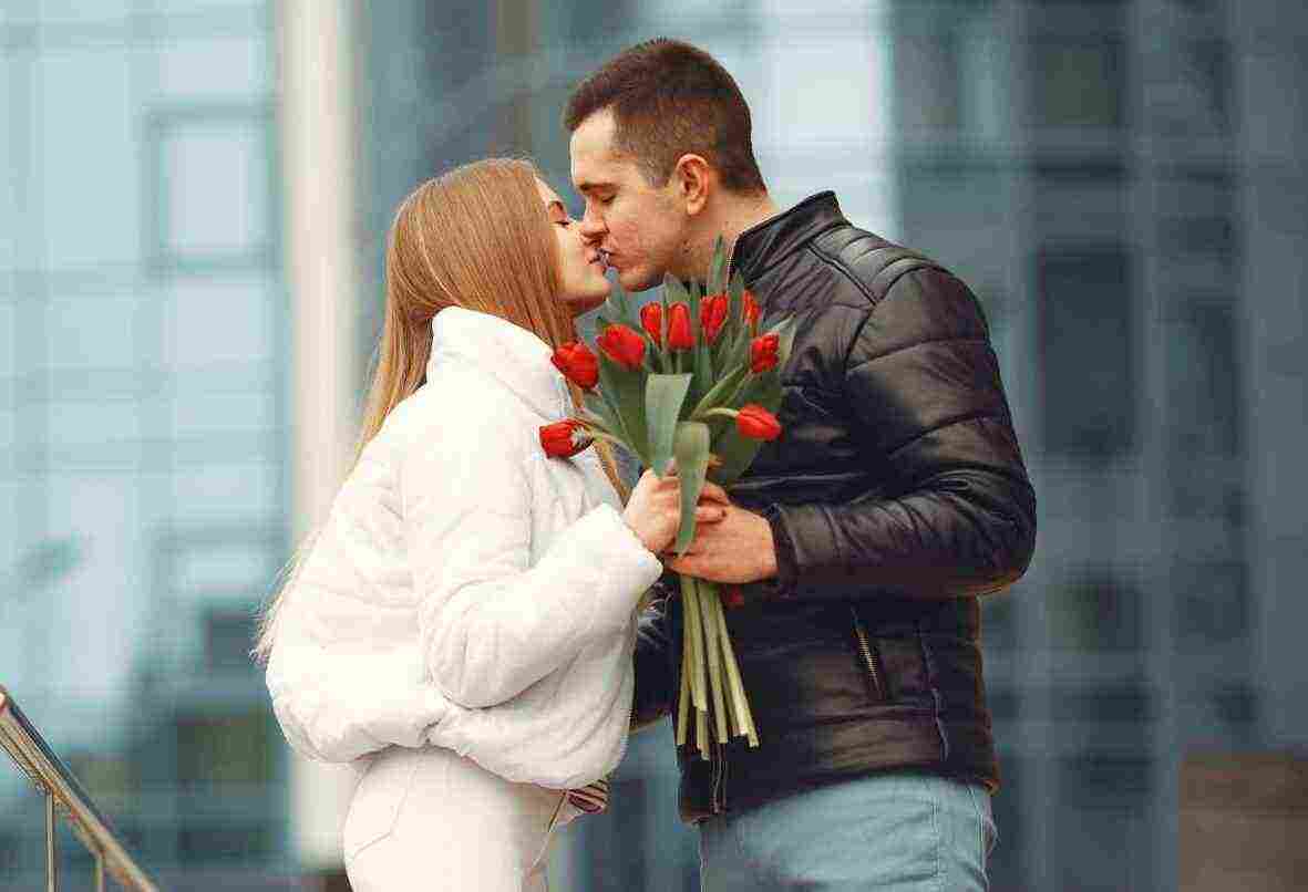 european couple is standing together with flowers e1684487054850