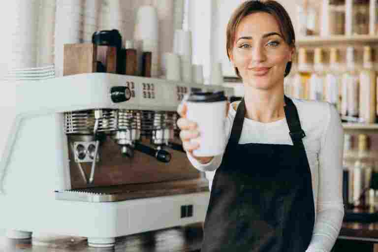 female barista worker coffee shop holding coffee cup