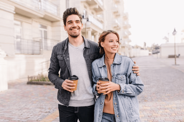 Guy wrapping his hands around girl's shoulder