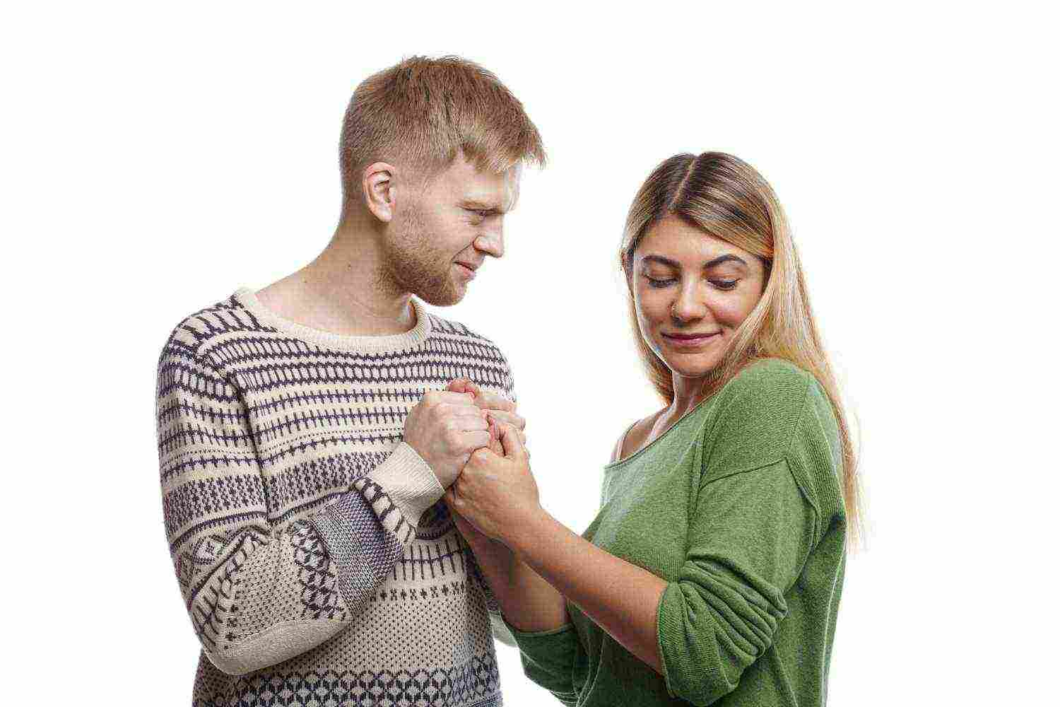 people relationships romance concept attractive young unshaven male confessing his love pretty cute girl while holding both her hands woman looking down with shy expression blushing