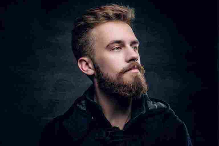 portrait bearded urban male isolated with contrast illumination grey vignette background