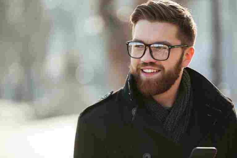 portrait happy bearded young man glasses standing outdoors