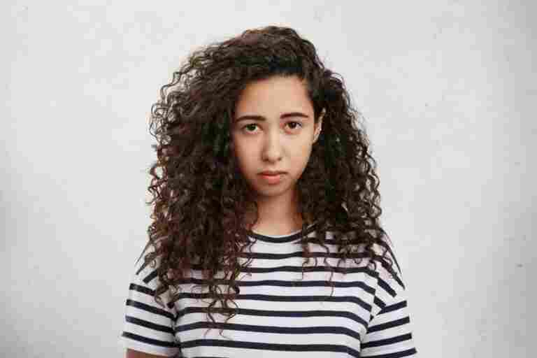 upset female has crisp hair sullen gloomy expression being displeased
