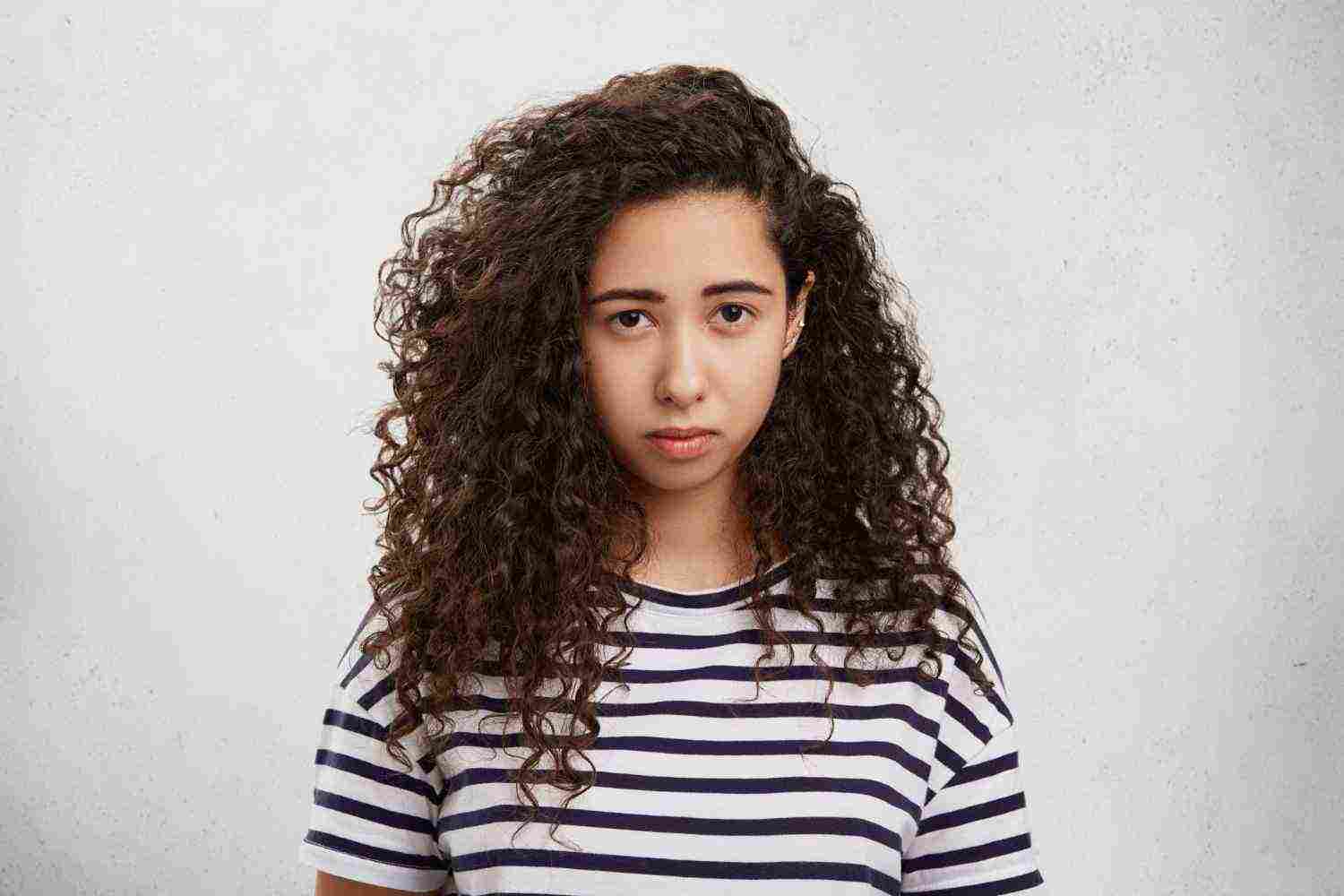 upset female has crisp hair sullen gloomy expression being displeased