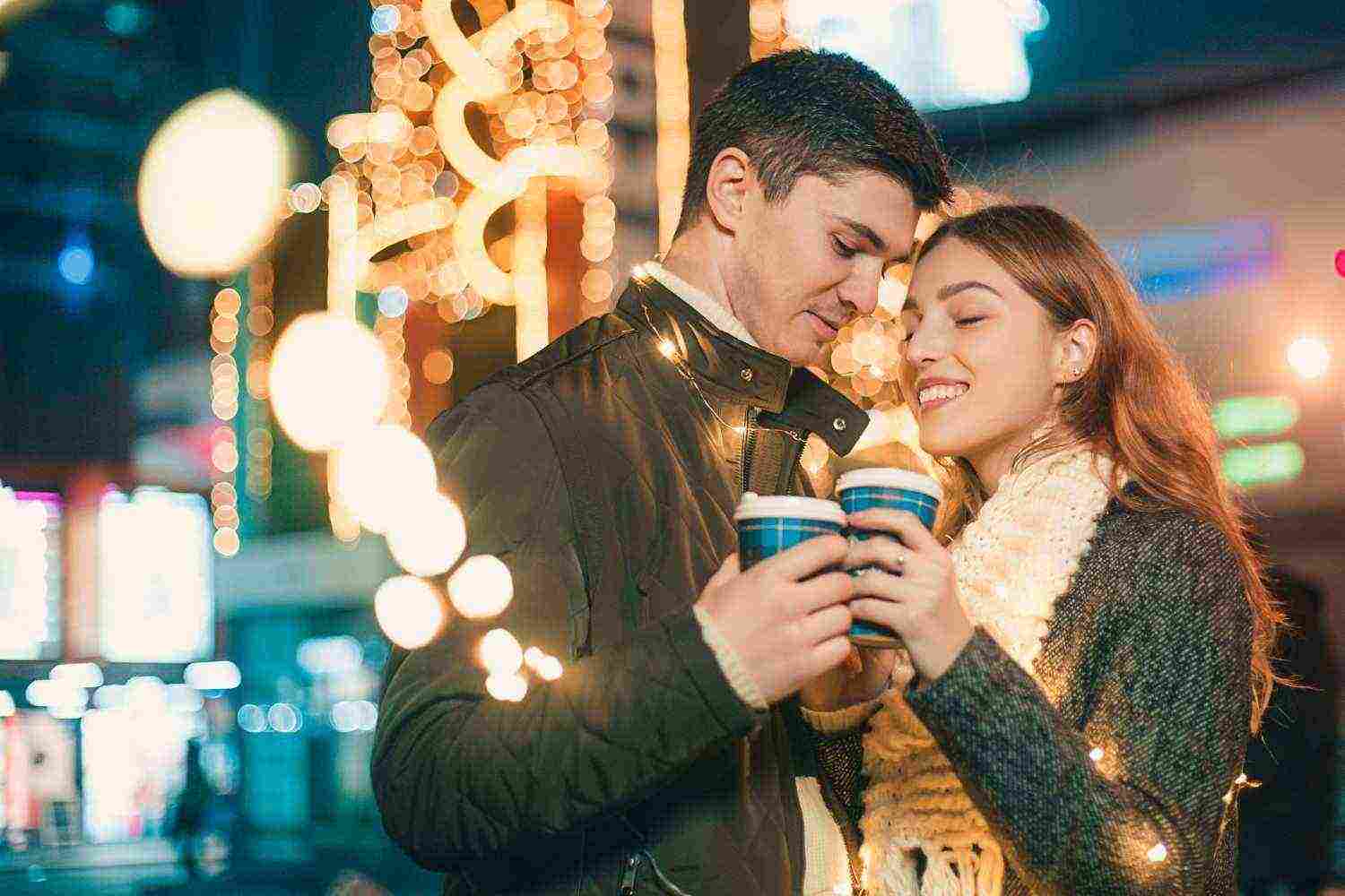young couple kissing hugging outdoor night street christmas time