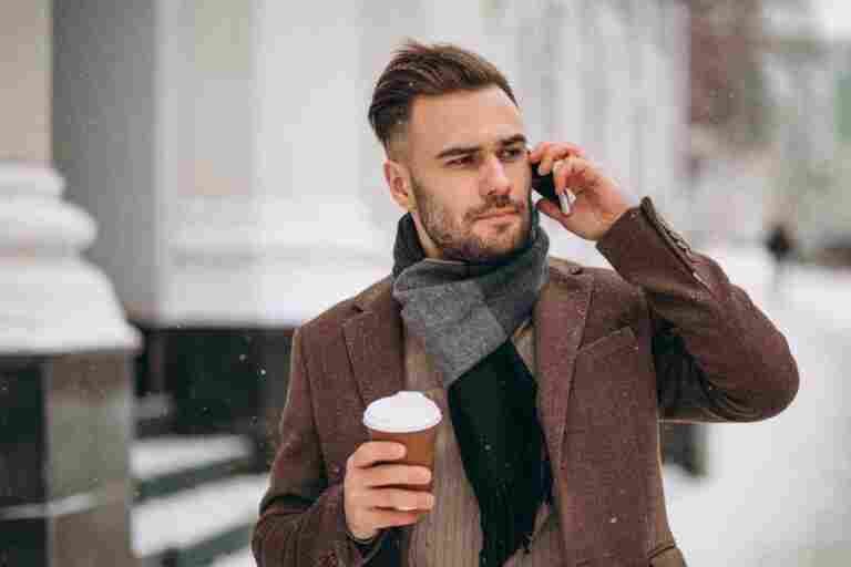 young handsome man drinking coffee talking phone