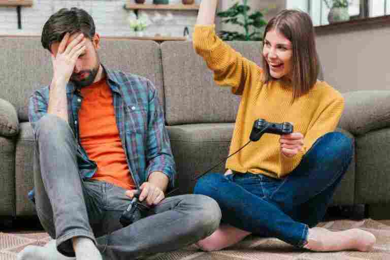 young woman cheering after winning video game with her husband 1