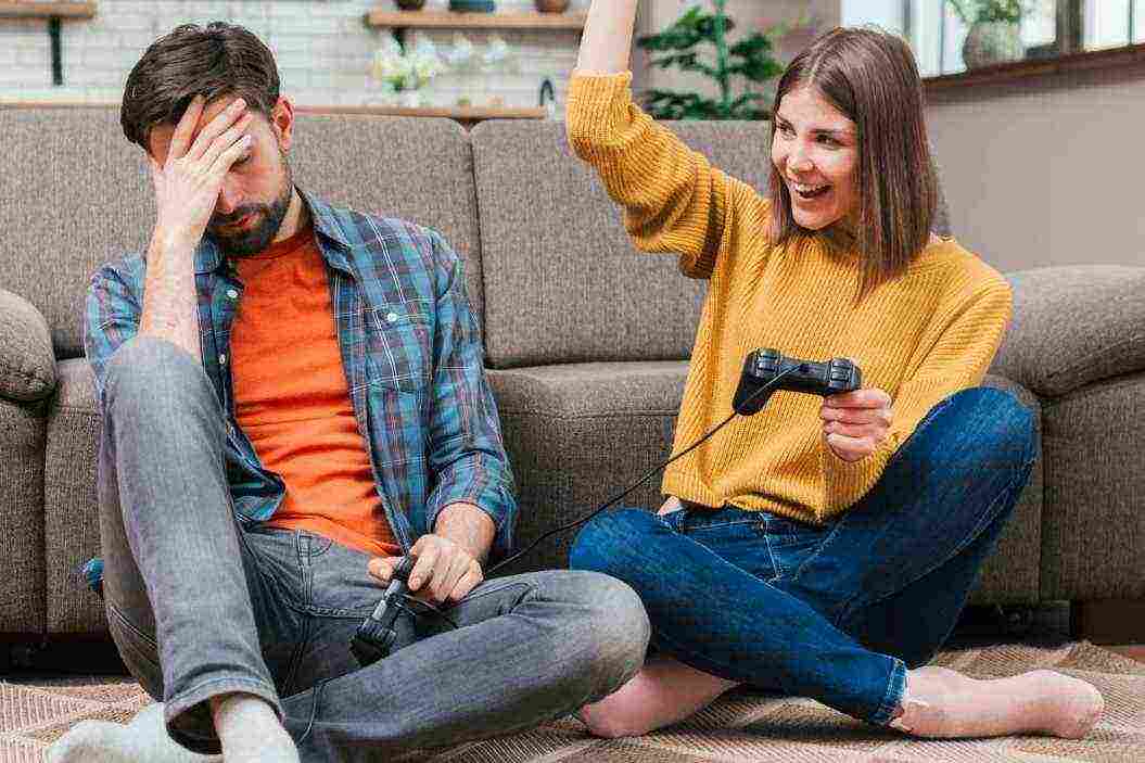 young woman cheering after winning video game with her husband 1