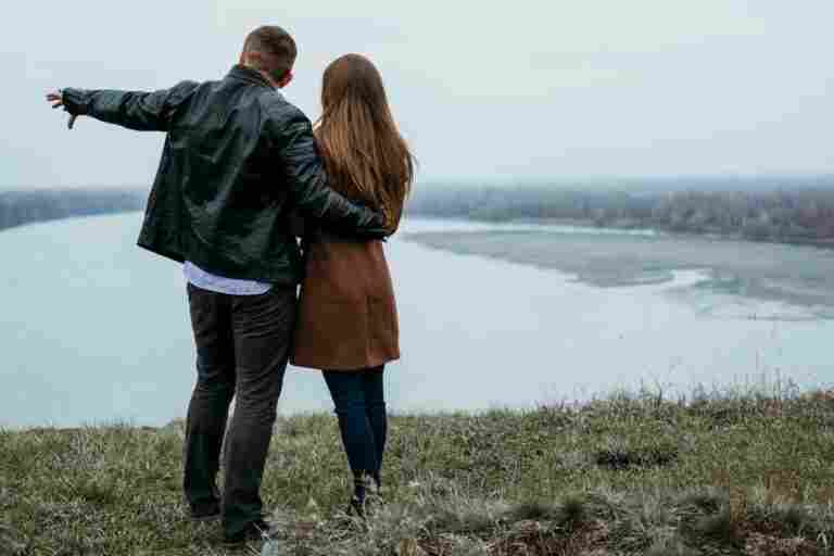 back view couple admiring lake view with copy space