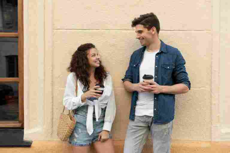 cute couple enjoying cup coffee outdoors