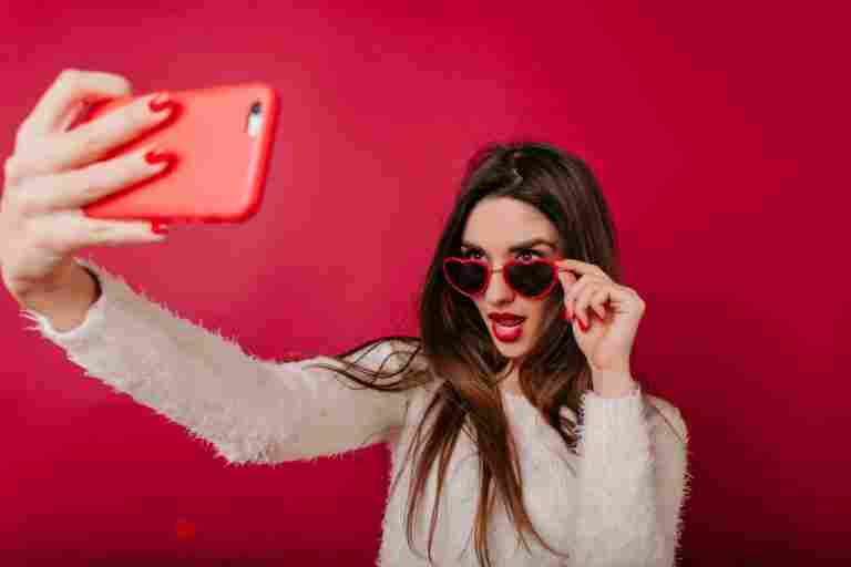 fascinating girl with red manicure taking picture herself
