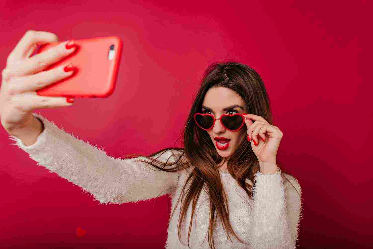 fascinating girl with red manicure taking picture herself