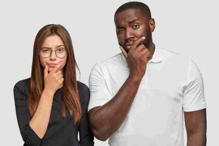 multiethnic friendship concept thoughtful doubtful caucasian woman handsome black man hold chins have puzzled expressions