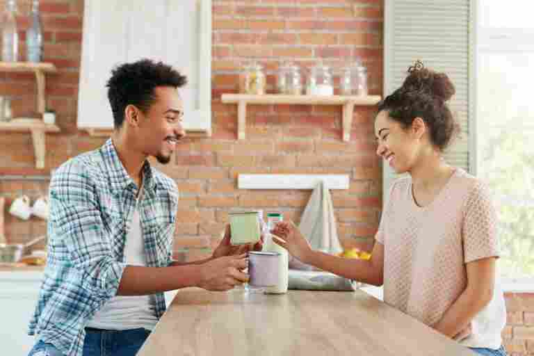 people feelings relationship mixed race couple spend free time together home drink milk sit near table
