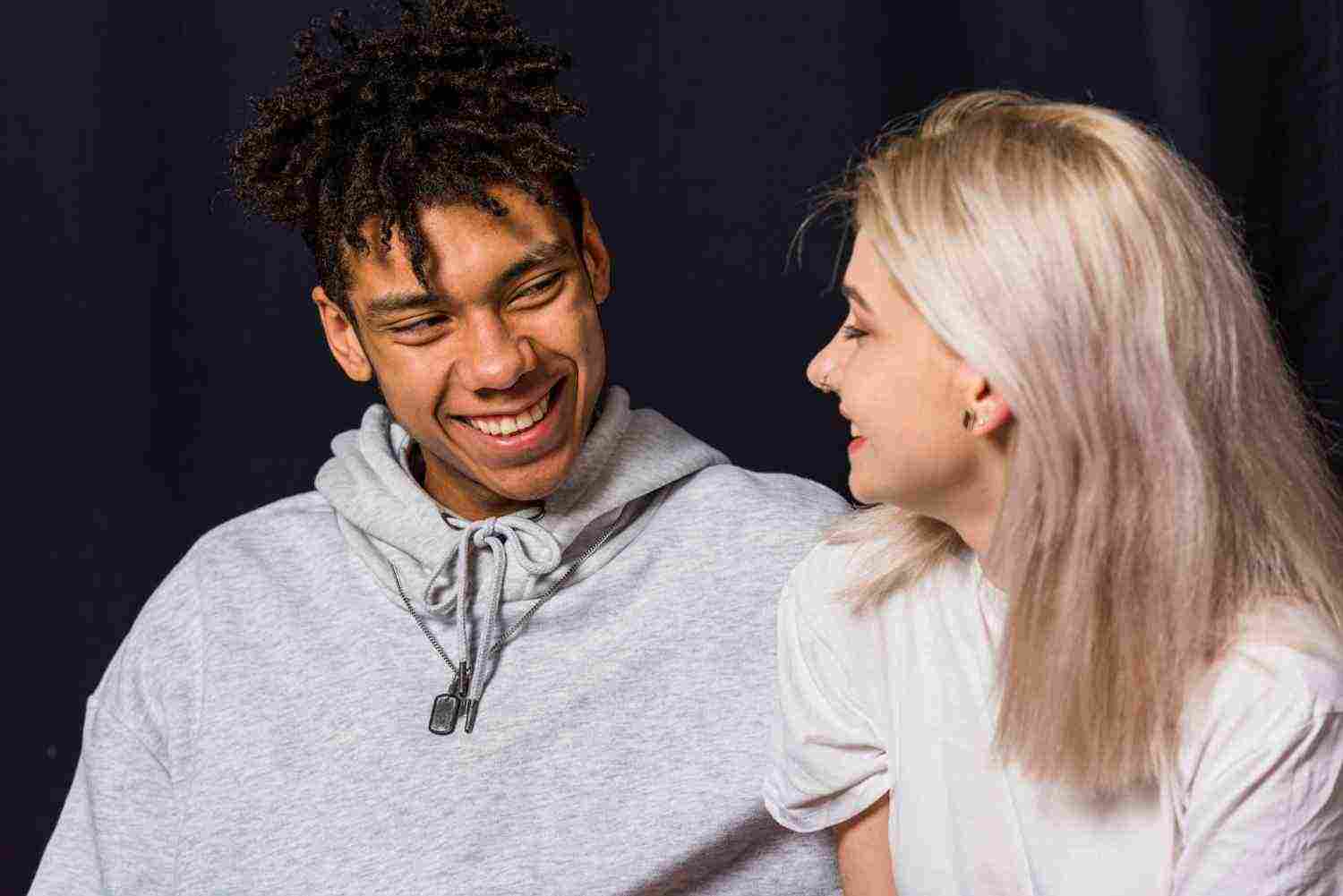 portrait happy young couple against black background