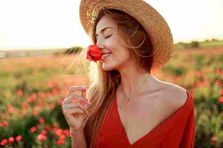 romantic blonde woman with flower hand walking amazing poppy field warm sunset colors straw hat red dress soft colors