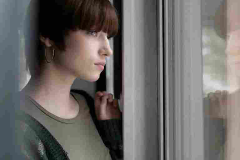 side view woman looking out window
