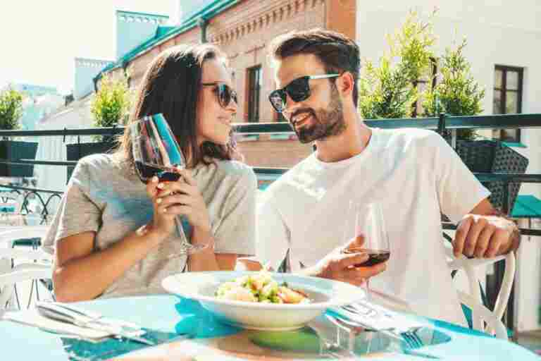 smiling beautiful woman her handsome boyfriend happy cheerful family couple cheering with glasses red wine their date restaurant they drinking alcohol veranda cafe street