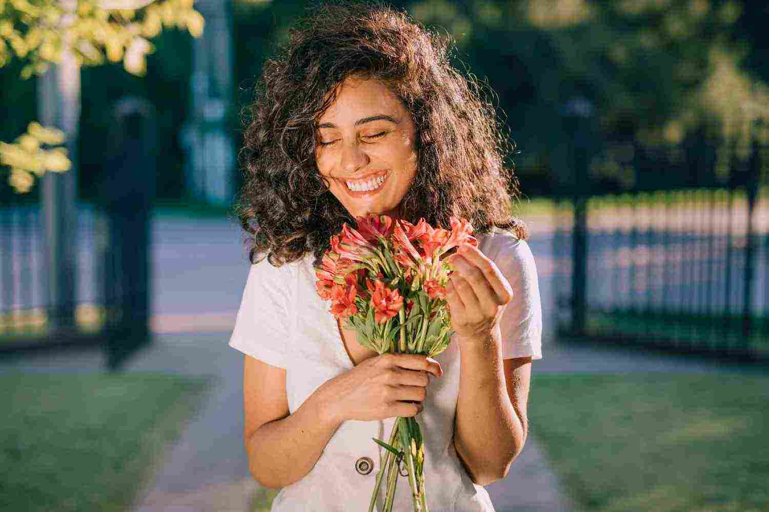 smiling young woman holding flower bouquet hand