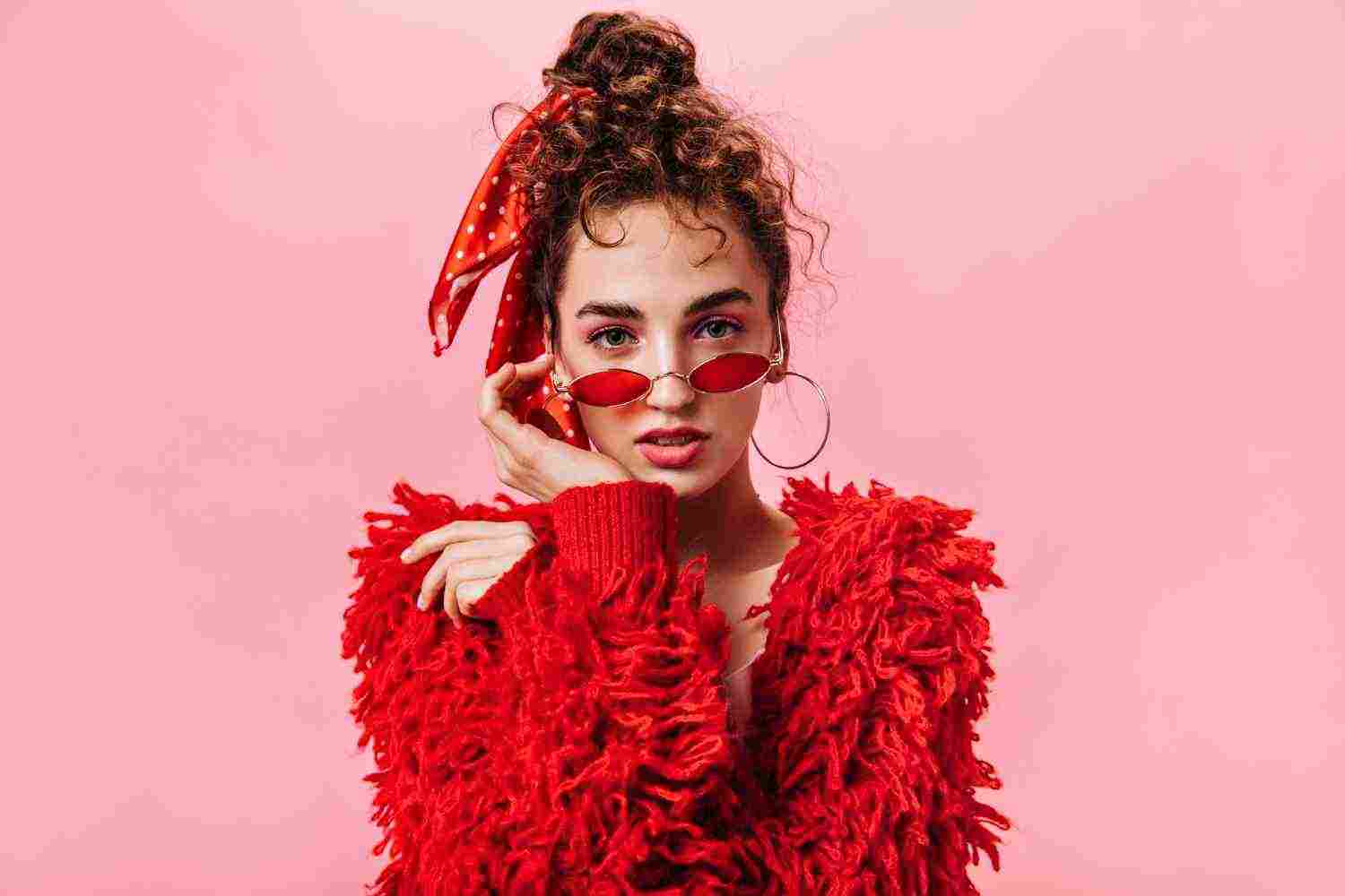 young woman fluffy jacket red sunglasses looking into camera