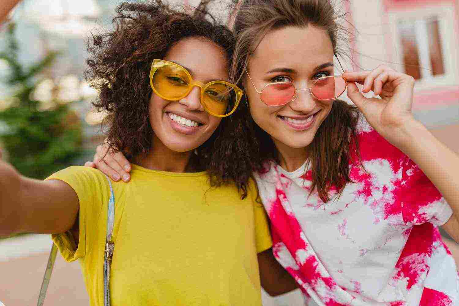 colorful portrait happy young girls friends smiling sitting street taking selfie photo mobile phone women having fun together