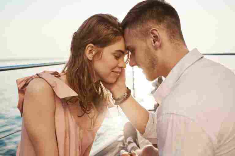 happy young couple love smiling enjoying boat trip sea romance vacation concept boyfriend tenderly touches her cheek girlfriend feels butterflies stomach