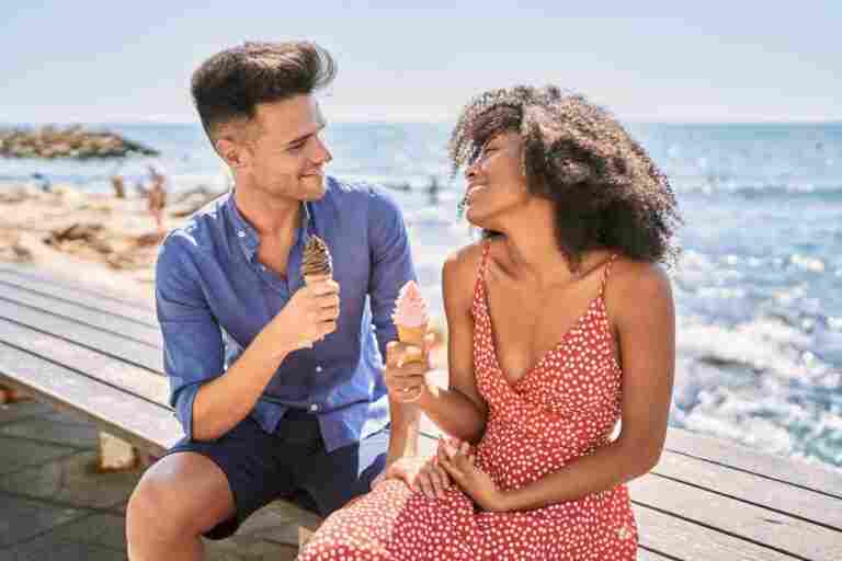 man woman couple smiling confident using smartphone seaside1