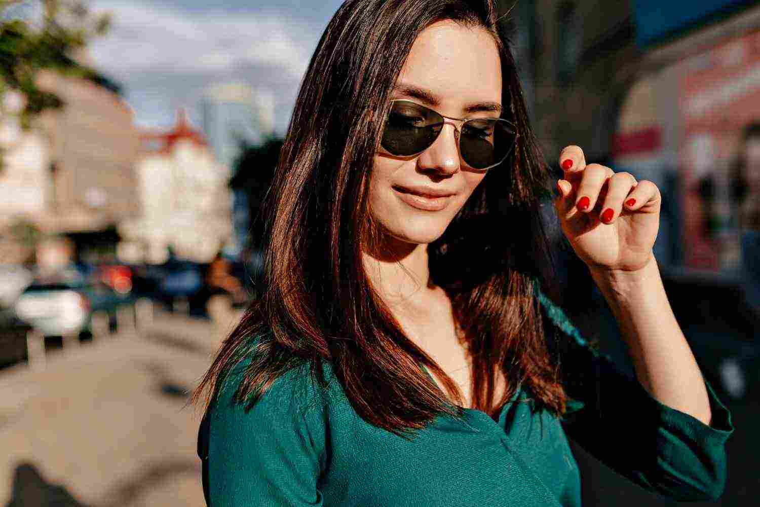 outside close up portrait charming european woman wearing black sunglasses green blouse posing