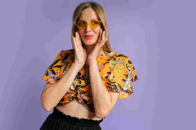 studio close up fashion portrait pretty blond woman stylish top linen shorts posing purple background