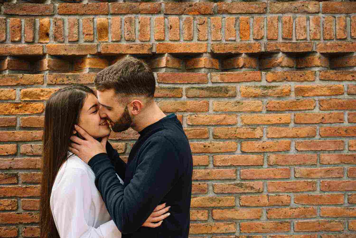 young couple kissing front wall