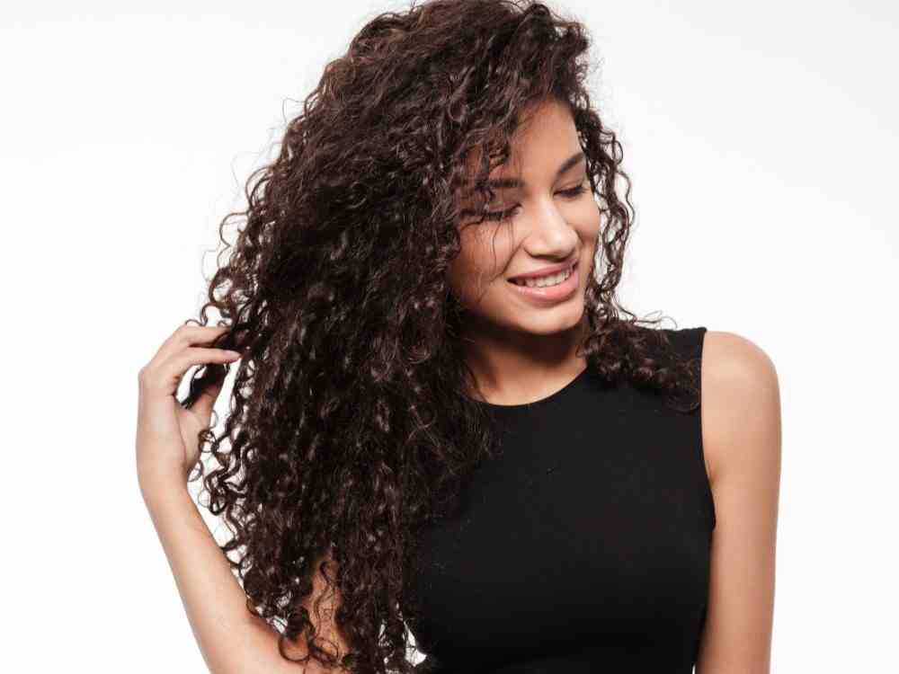 beautiful young curly african lady posing white background