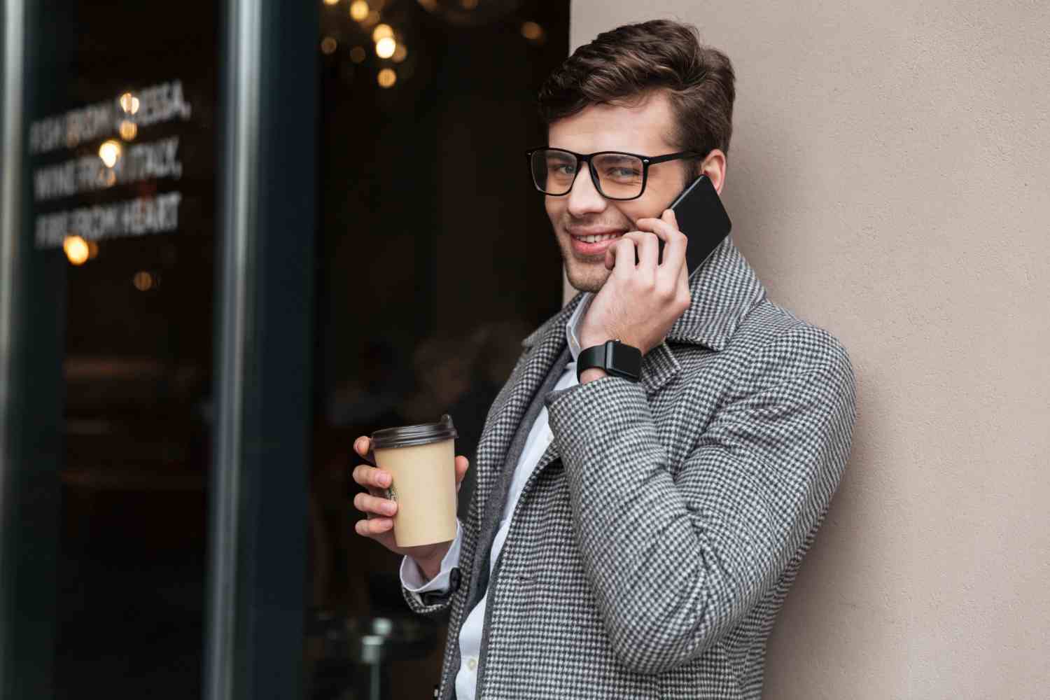 cheerful businessman eyeglasses coat talking by smartphone