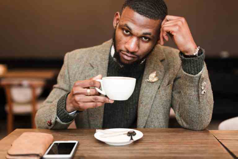 handsome man holding cup with coffee while looking up