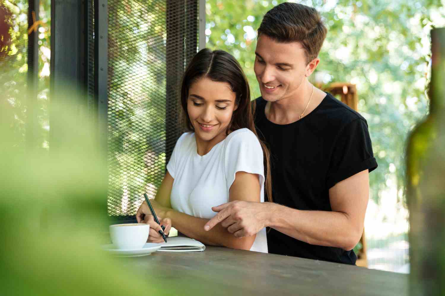 happy smiling woman making notes textbook