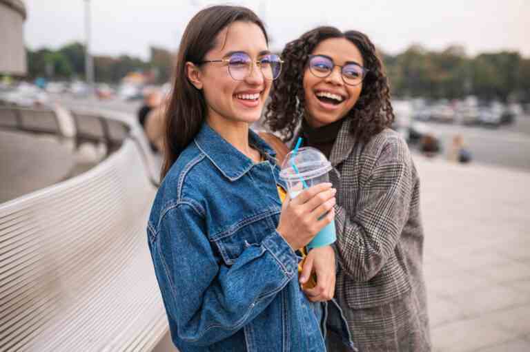 smiley friends having fun together outside with milkshakes