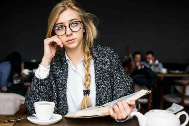 thoughtful woman with book cafe