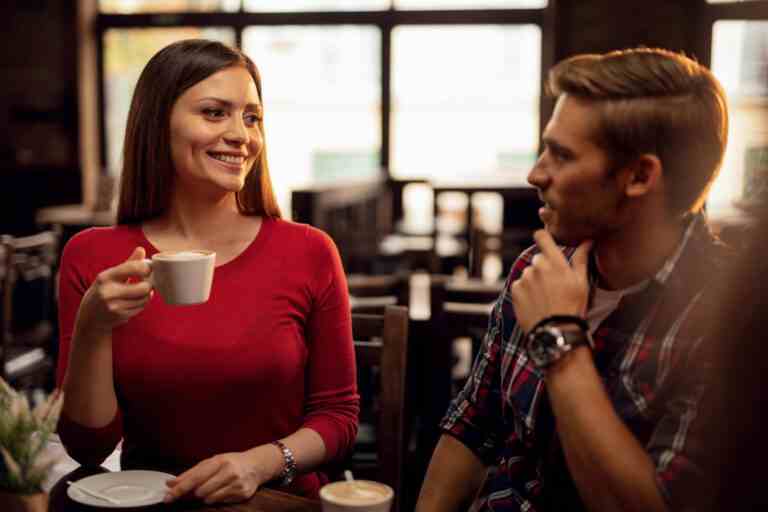 young happy couple talking each other while drinking coffee cafe focus is woman