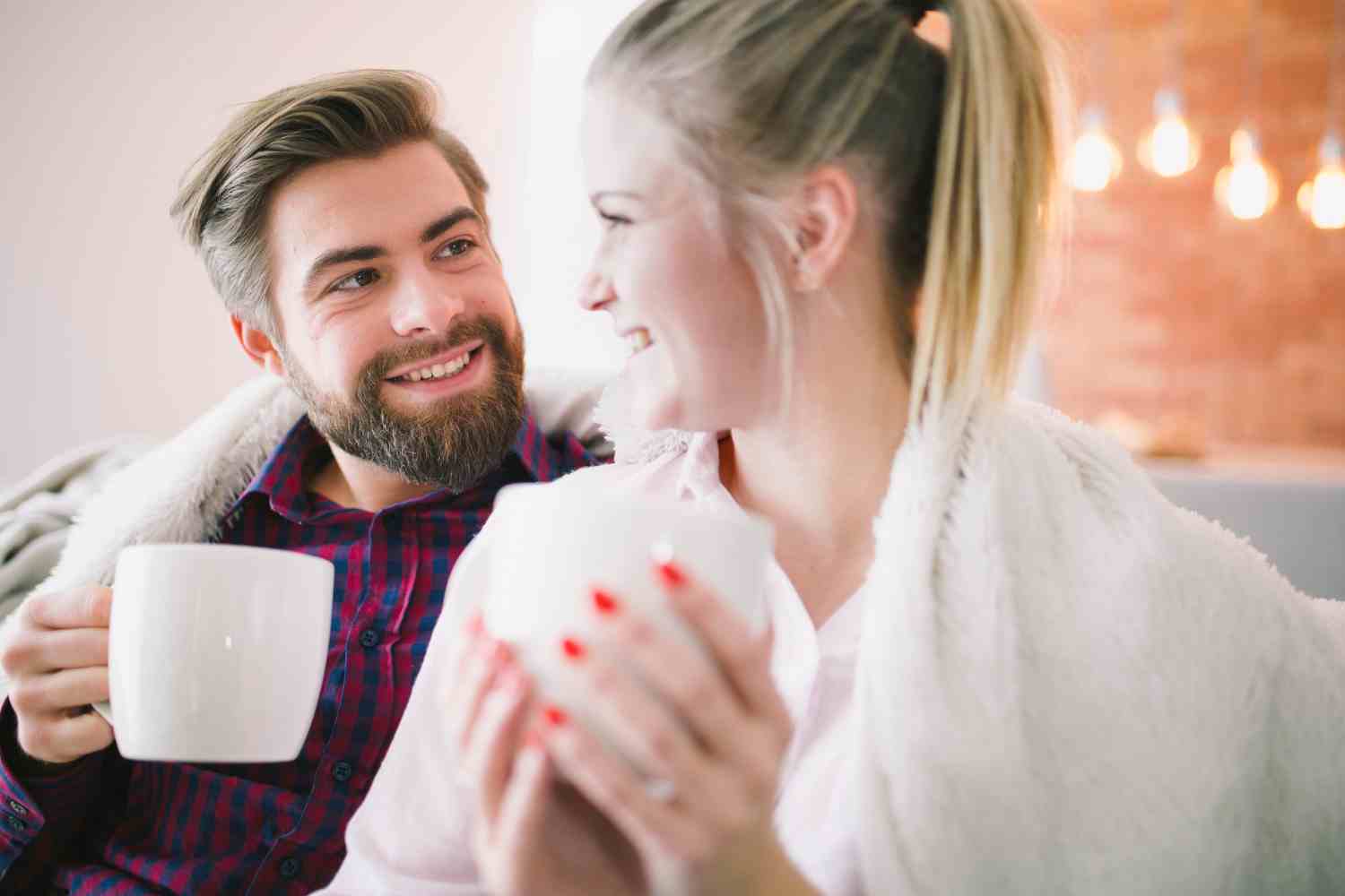 cheerful couple with cups plaid