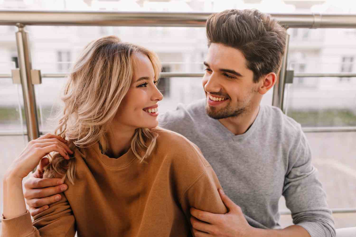 glad guy embracing girlfriend portrait caucasian couple smiling each other